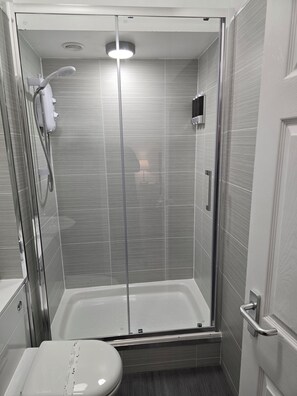 A modern bathroom with a glass-enclosed shower, a toilet, and a sink. - The Boot & Shoe (Darlington)