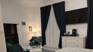 A hotel room with a large bed, a desk with a lamp, a chair, and a TV. - The Boot & Shoe (Darlington)