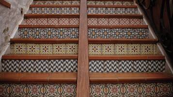 A staircase with ornate tiled steps and a wooden handrail.