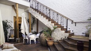 A courtyard with a stone staircase, outdoor seating, and potted plants. - Terra Diaguita Hotel Boutique & Spa (La Serena)