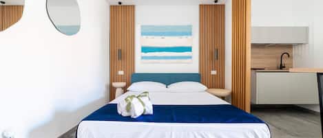 Ein modernes Hotelzimmer mit Bett, Schreibtisch und einem Strandbild.