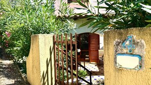 Ein Haus mit Tor, Hausnummer und gefliestem Patio.