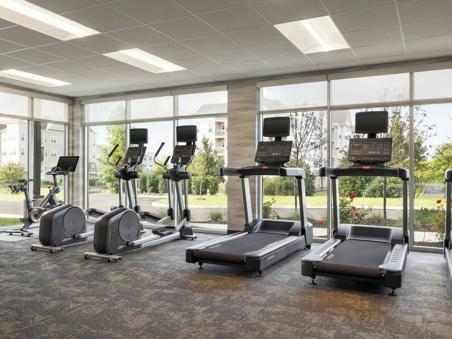 A gym with treadmills, elliptical machines, and stationary bikes.