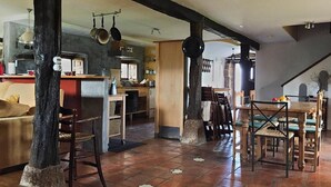 A spacious living area with a kitchen, dining table, and chairs. - Country House 'La Casa Del Chileno' with Sea View, Private Terrace and Private Garden (Lierganes)