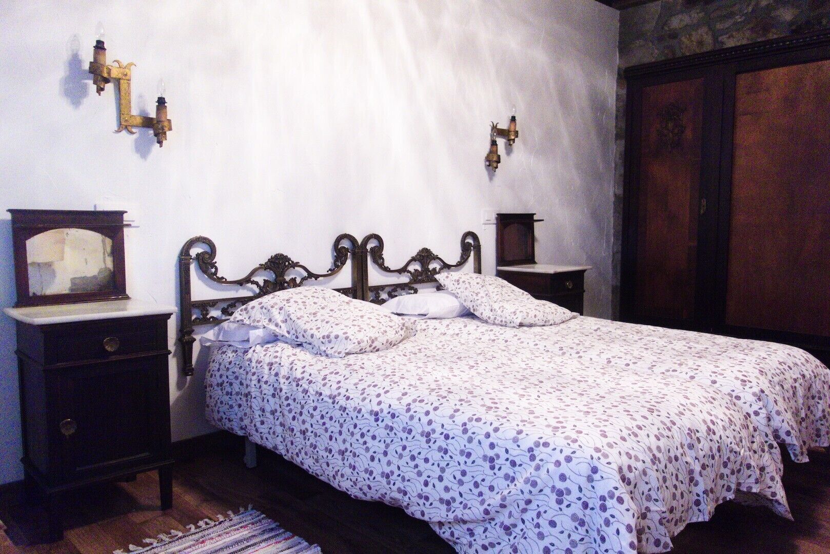 Un dormitorio con cama, mesitas de noche, cómoda y espejo.