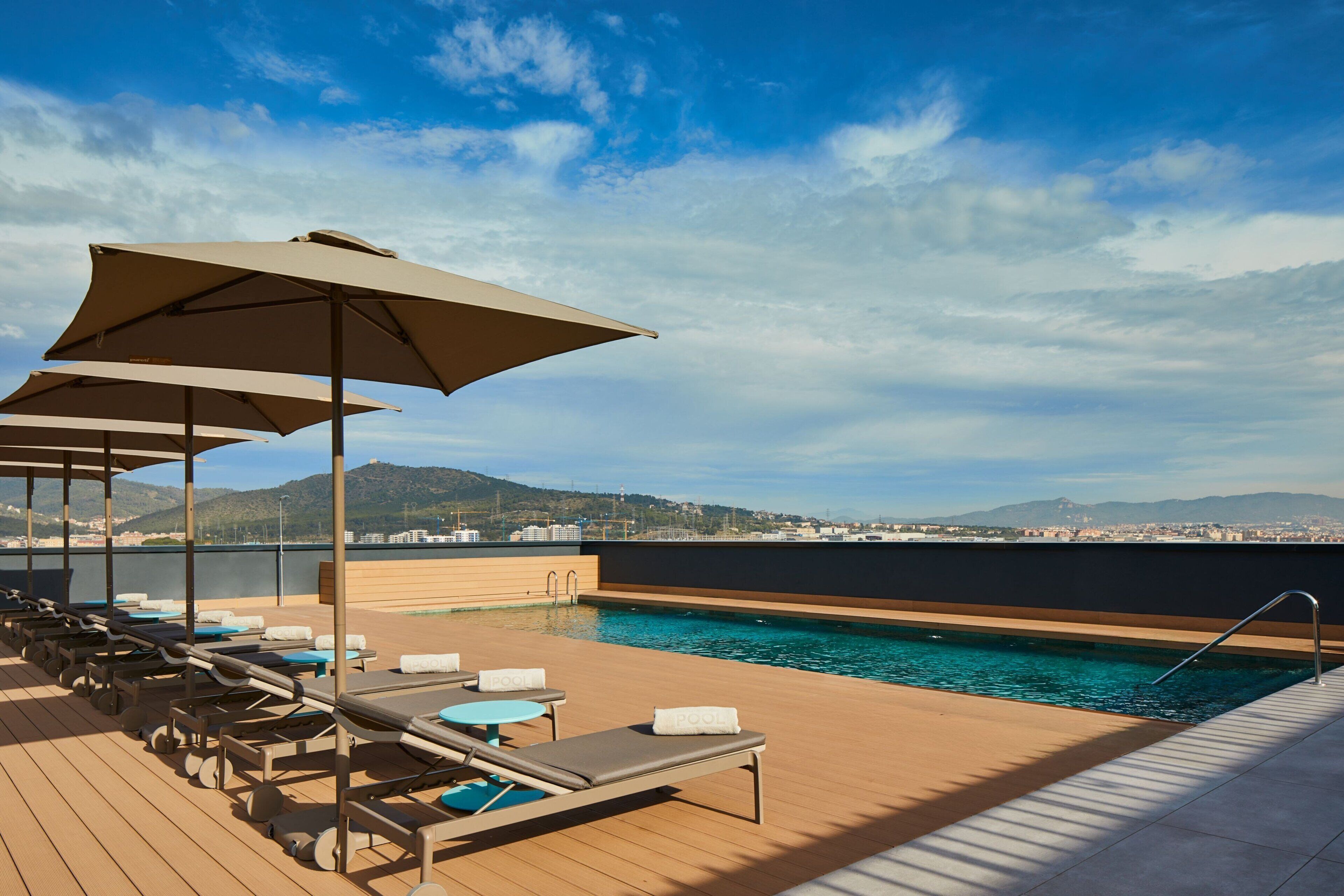 室外游泳池，池畔遮阳伞，日光浴躺椅