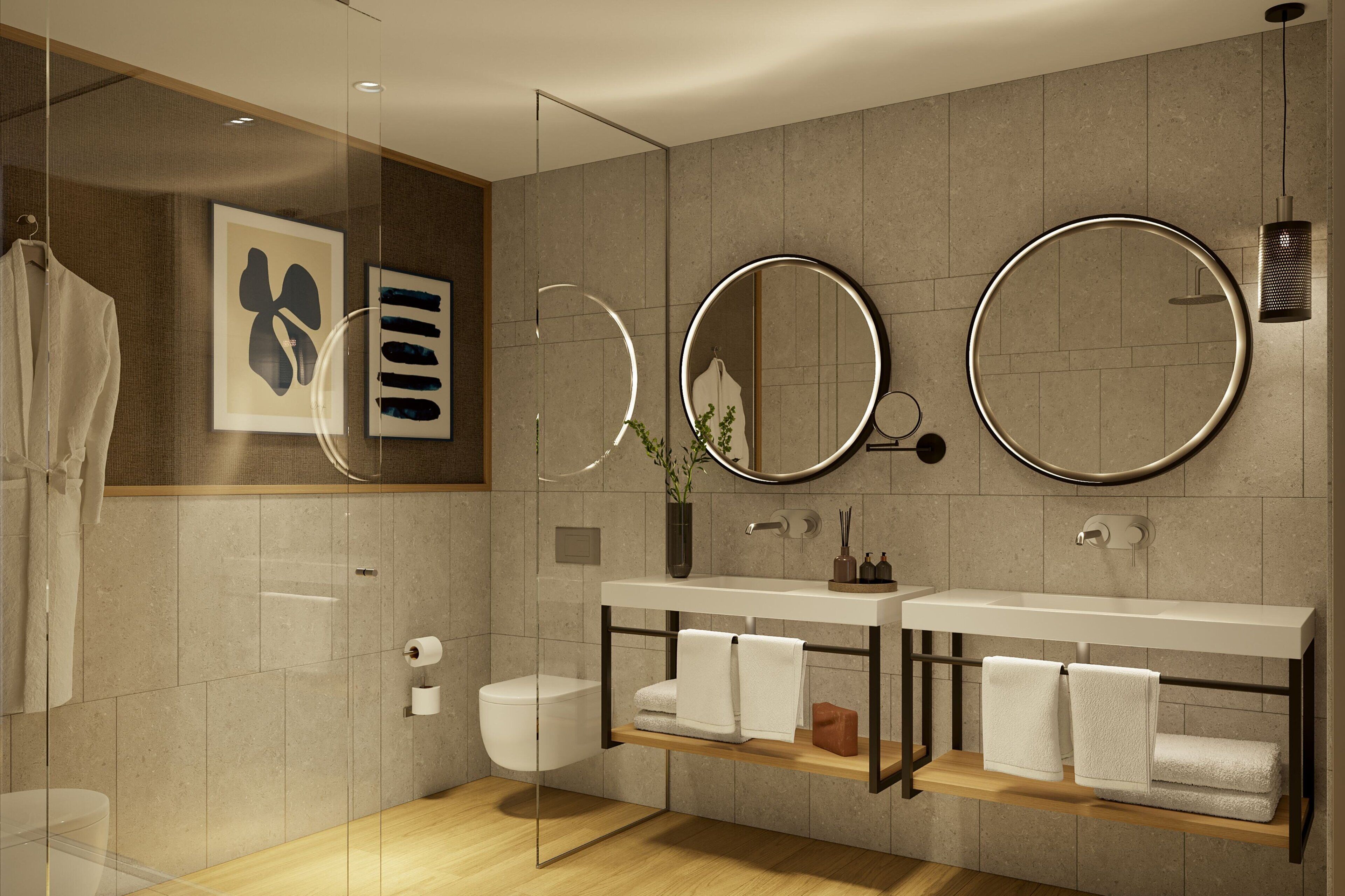 Un baño moderno con cabina de ducha de vidrio, un tocador doble con dos lavamanos y un espejo grande sobre el tocador.