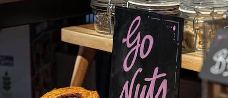 Mostrador de pastelería con productos de repostería y un letrero que dice 'Go Nuts'.