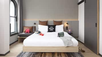 A modern bedroom with a large bed, a headboard with built-in lighting, a bedside table with a lamp, and a window with curtains.