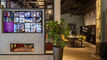 A modern interior with a large display wall, a potted plant, and a seating area.