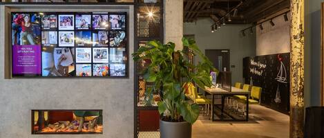 Un interior moderno con una pared de grandes dimensiones, una planta en maceta y una zona de estar.