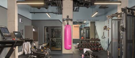 A gym with treadmills, weights, and a punching bag.