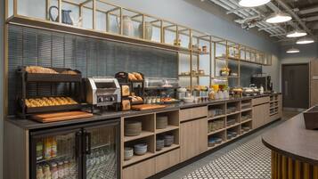 Uma cozinha moderna com estação de café integrada, vitrine refrigerada e diversos utensílios de cozinha.