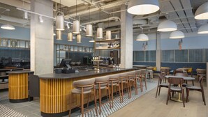Un espace bar moderne comprenant un comptoir, des tabourets et des sièges.