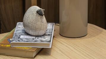 Una mesa con una lámpara, un huevo decorativo y un libro titulado 'Stamford Bridge'.