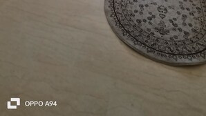 Una sala de estar moderna con un sofá color beige, una mesita de centro y una alfombra estampada.
