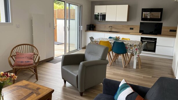 Un appartement moderne comprenant un coin repas, une cuisine et un espace salon.