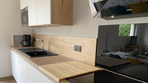 Une cuisine moderne dotée d’un plan de travail en bois, d’une cuisinière encastrée et d’une machine à café.