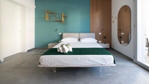 Une chambre moderne avec un lit, une lampe fixée au mur et un mur recouvert de panneaux en bois.