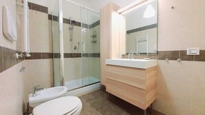 Een douche, een haardroger, een bidet, handdoeken