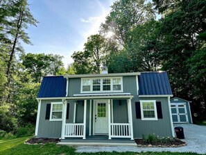 A two-story house with a front porch, solar panels, and a garage.