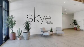 A modern interior with a sign reading "skye on 6th". There are potted plants and two chairs in the space. - Walk Everywhere! 1BR nr Zoo, Desert Garden, ASU (Phoenix)