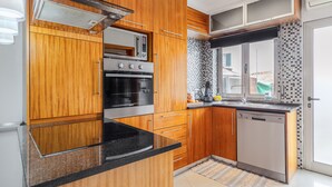 Une cuisine moderne avec des meubles en bois, un four encastré et un lave-vaisselle.