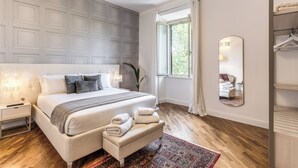 Une chambre à coucher moderne avec un grand lit, des lampes de chevet, un miroir et une vue sur l’extérieur.