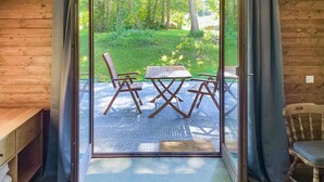 A wooden cabin with a sliding glass door leading to an outdoor patio with a table and chairs. - 2 bedroom awesome home in Ferlach (Ferlach)