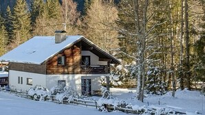A wooden cabin with a snow-covered roof, surrounded by trees and a snowy landscape. - 2 bedroom awesome home in Ferlach (Ferlach)