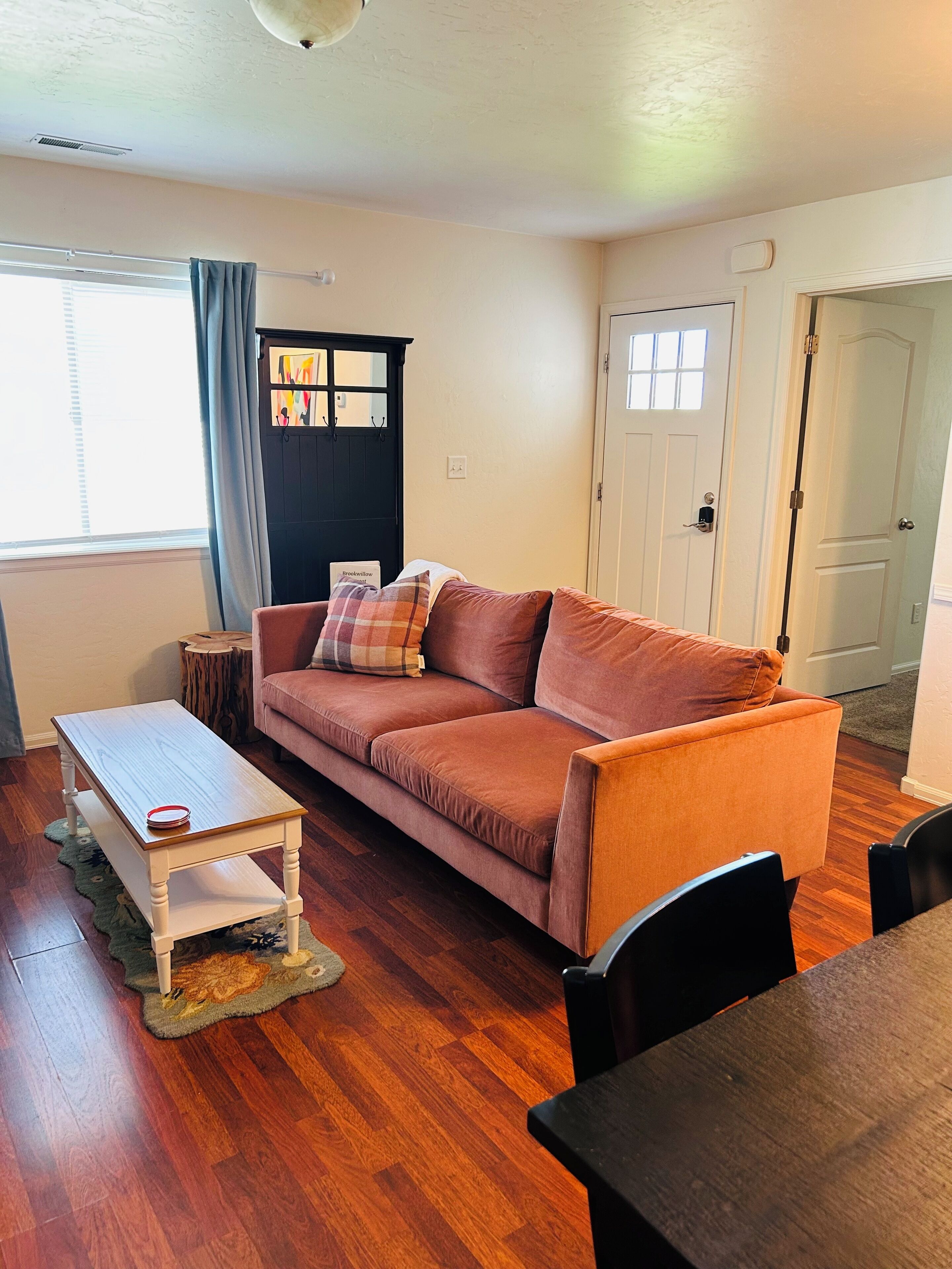 A living room with a sofa, a coffee table, and a dining table.