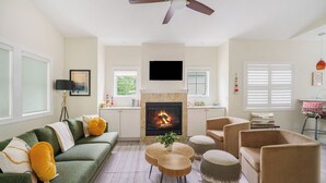 A living room with a fireplace, a sofa, armchairs, and a coffee table.