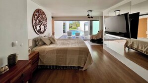 A modern bedroom with a large bed, a TV, and a view of the outdoors. - Da Serra Guest House (Azeitão)