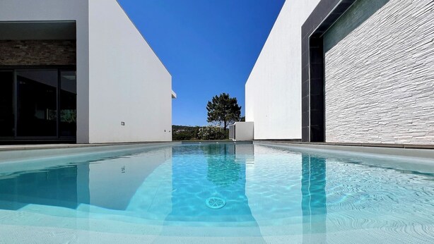 A modern building with a swimming pool in the foreground. - Da Serra Guest House (Azeitão)