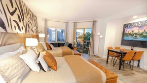 Ein Hotelzimmer mit zwei Betten, einem Essbereich und einem Balkon mit Blick.