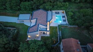 A modern house with a swimming pool, multiple rooms, and a well-maintained garden.