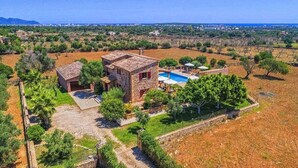 A stone villa with a swimming pool, surrounded by olive groves and a clear view of the city.