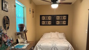 A bedroom with a bed, wooden dresser, desk, and decorative items. - Cozy cabin in Glen Rose with AC, WiFi, Close to all major attractions! (Glen Rose)