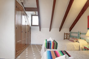 A bedroom with two beds, wooden wardrobe, and a window. - Holiday Home 'Casa El Pino' with Shared Pool, Wi-Fi and Air Conditioning (Barbate)