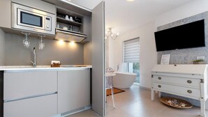 A modern bathroom with a built-in shower, a vanity with a mirror, a sink, and a toilet. - Eco del Garda - Deluxe Studio 101 with Covered Terrace and Lake View (Tenno)