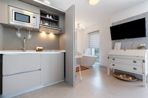 A modern bathroom with a built-in shower, a vanity with a mirror, a sink, and a toilet. - Eco del Garda - Deluxe Studio 101 with Covered Terrace and Lake View (Tenno)
