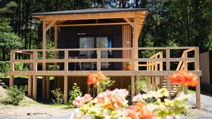 Eine Holzhütte mit Balkon, umgeben von einem Wald.