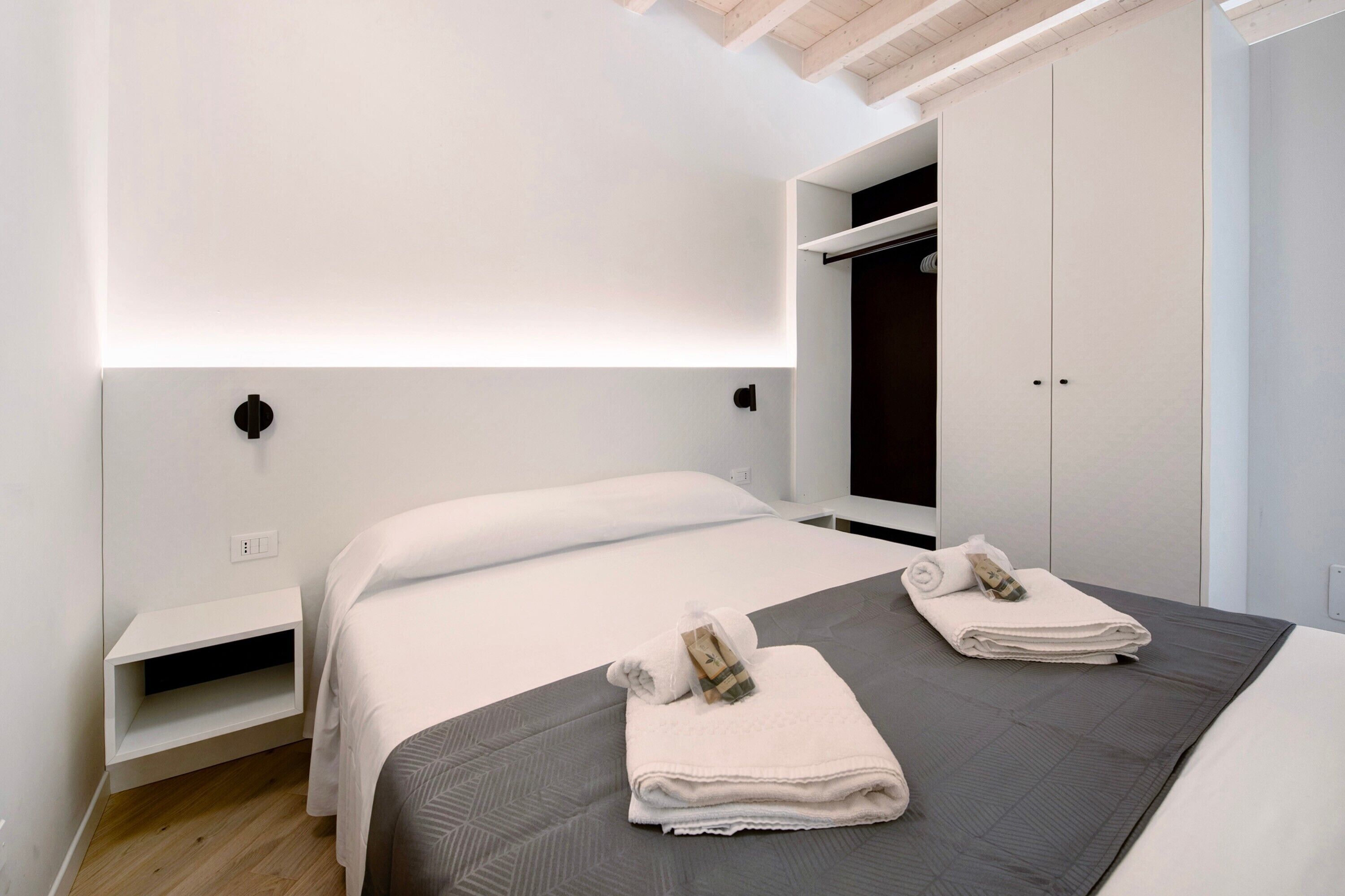 Habitación de hotel con cama, armario y estantería.