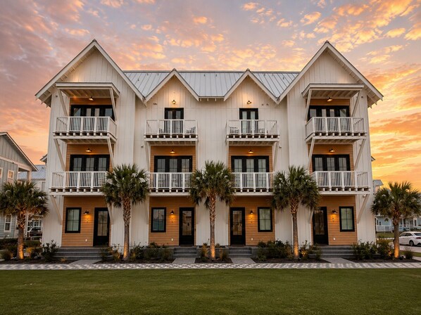 Un hotel de varios pisos con balcones, techo plano y un césped bien cuidado.