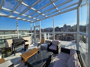 A rooftop terrace with glass walls, outdoor furniture, and a city view. - PrivatePremiumSeocho's Happy House 330m2 (Seoul)