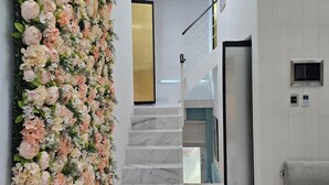 A modern interior with a marble staircase, a floral wall, and a minimalist design.