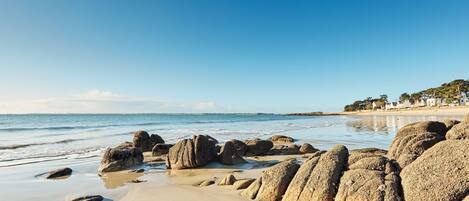 Enjoy the serene beach scene with a sandy shoreline and gentle ocean waves.