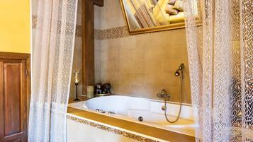 A bathroom with a bathtub, a shower, and a mirror above the tub.