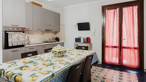 Une cuisine avec une table dressée pour le repas, un four à micro-ondes et un téléviseur fixé au mur.