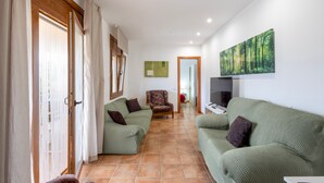Ein Wohnzimmer mit einer Couch, einem Sessel und einem Bild an der Wand.